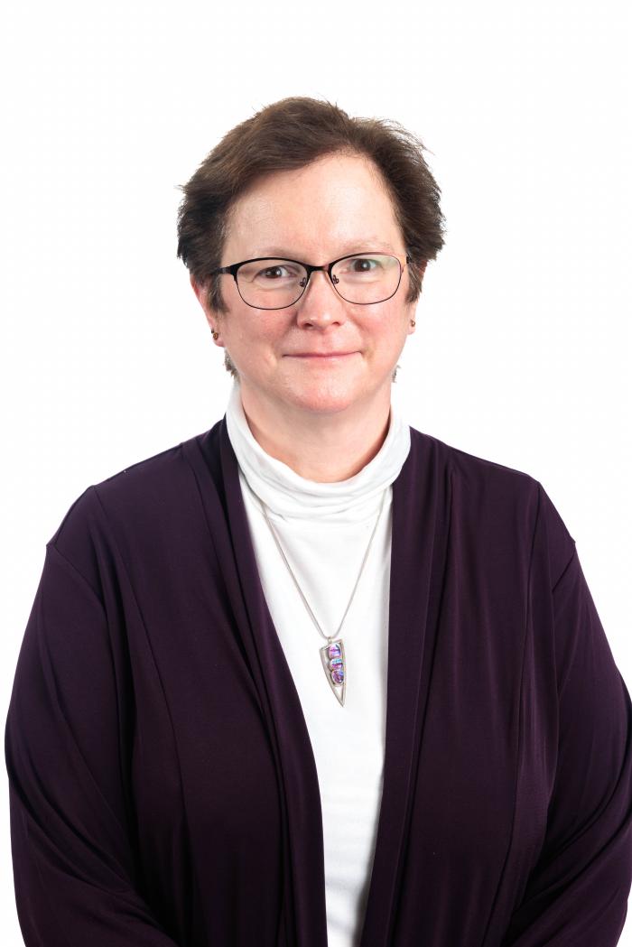 Headshot of Shelley Brundage standing in front of a blank background.